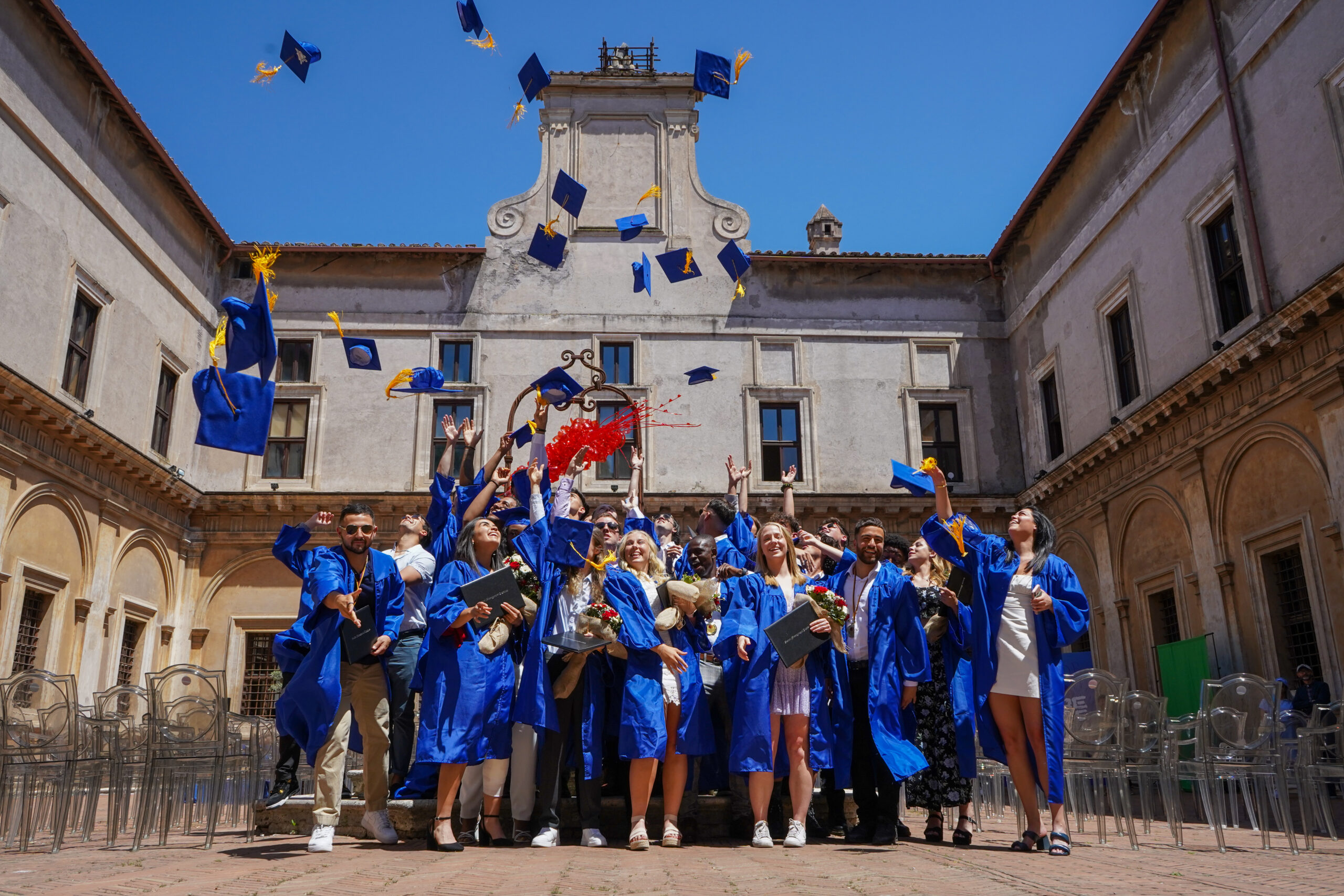 Rome City Institute graduates celebrating in the campus courtyard