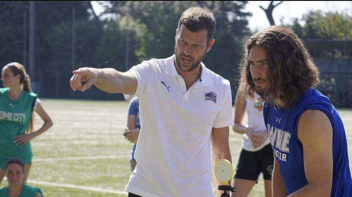 A Rome City Institute coach instructing student-athletes on the field