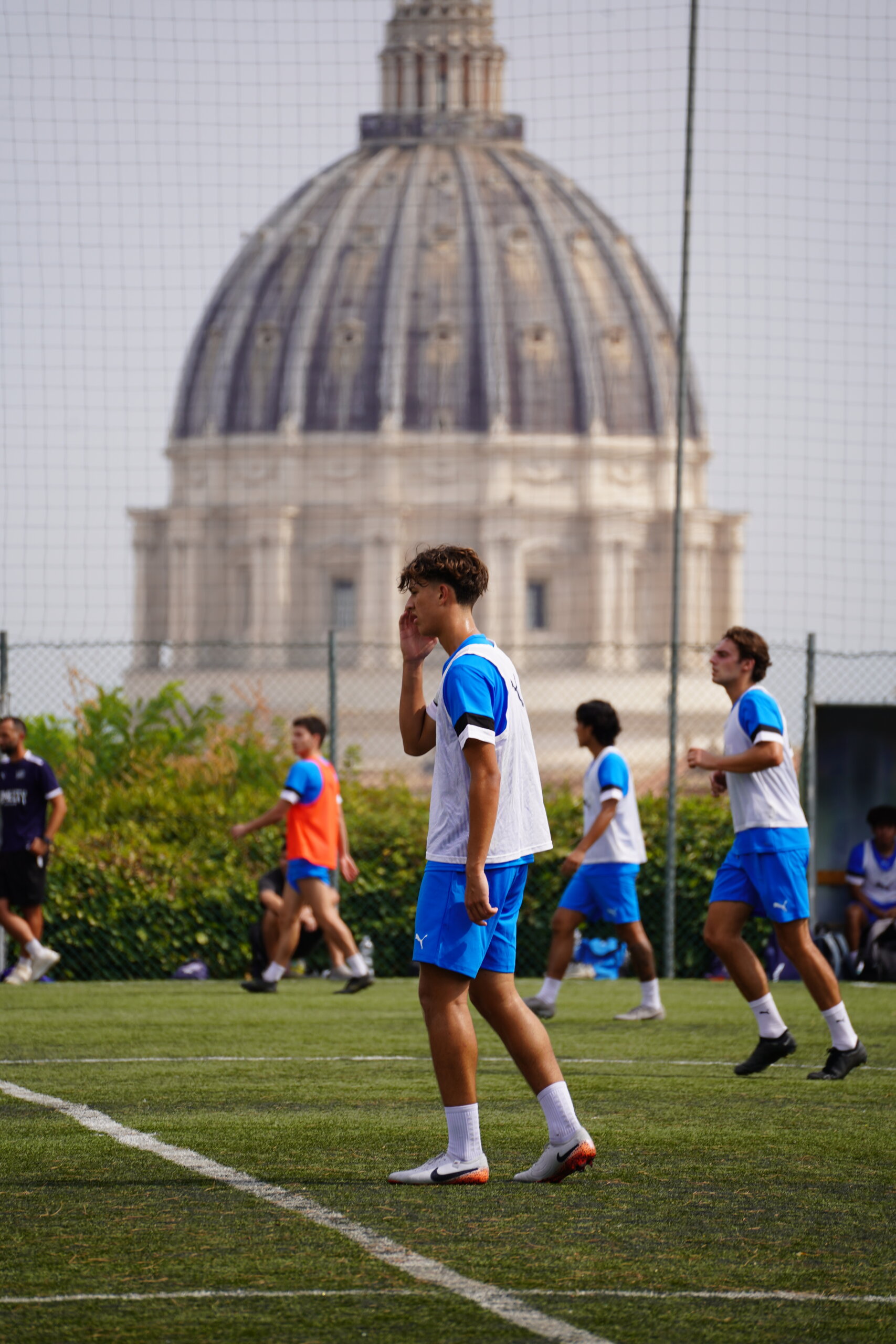 Rome City Prep Academy soccer players training with St. Peter's Basilica dome in the distance