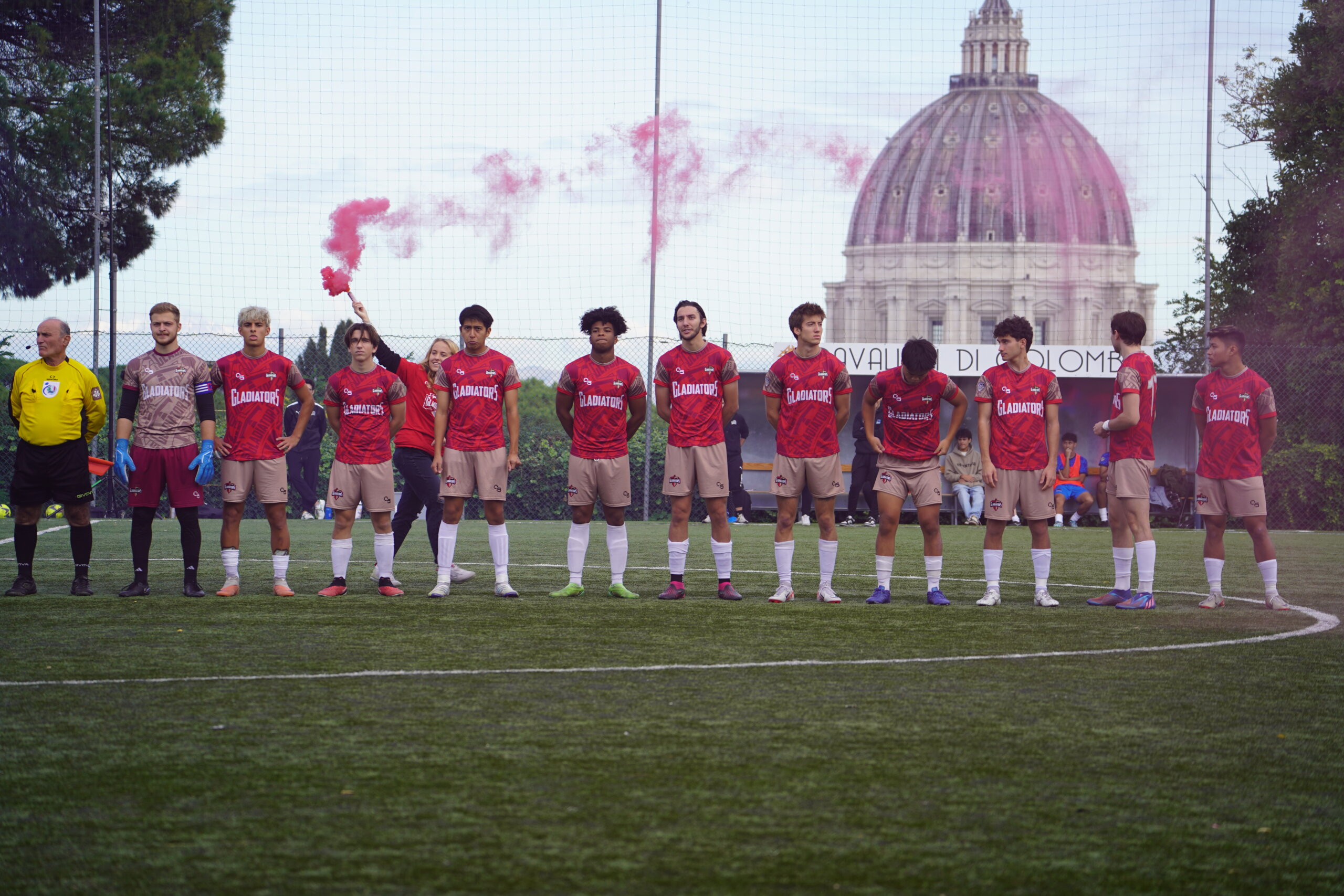 Rome City Institute soccer team lined up before a match with St. Peter's Basilica dome in the distance